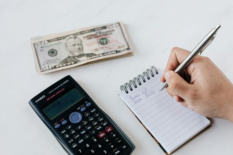 pexels-photo-4386339 | Beyond The Punchlines crop anonymous financier planning budget writing numbers in notebook