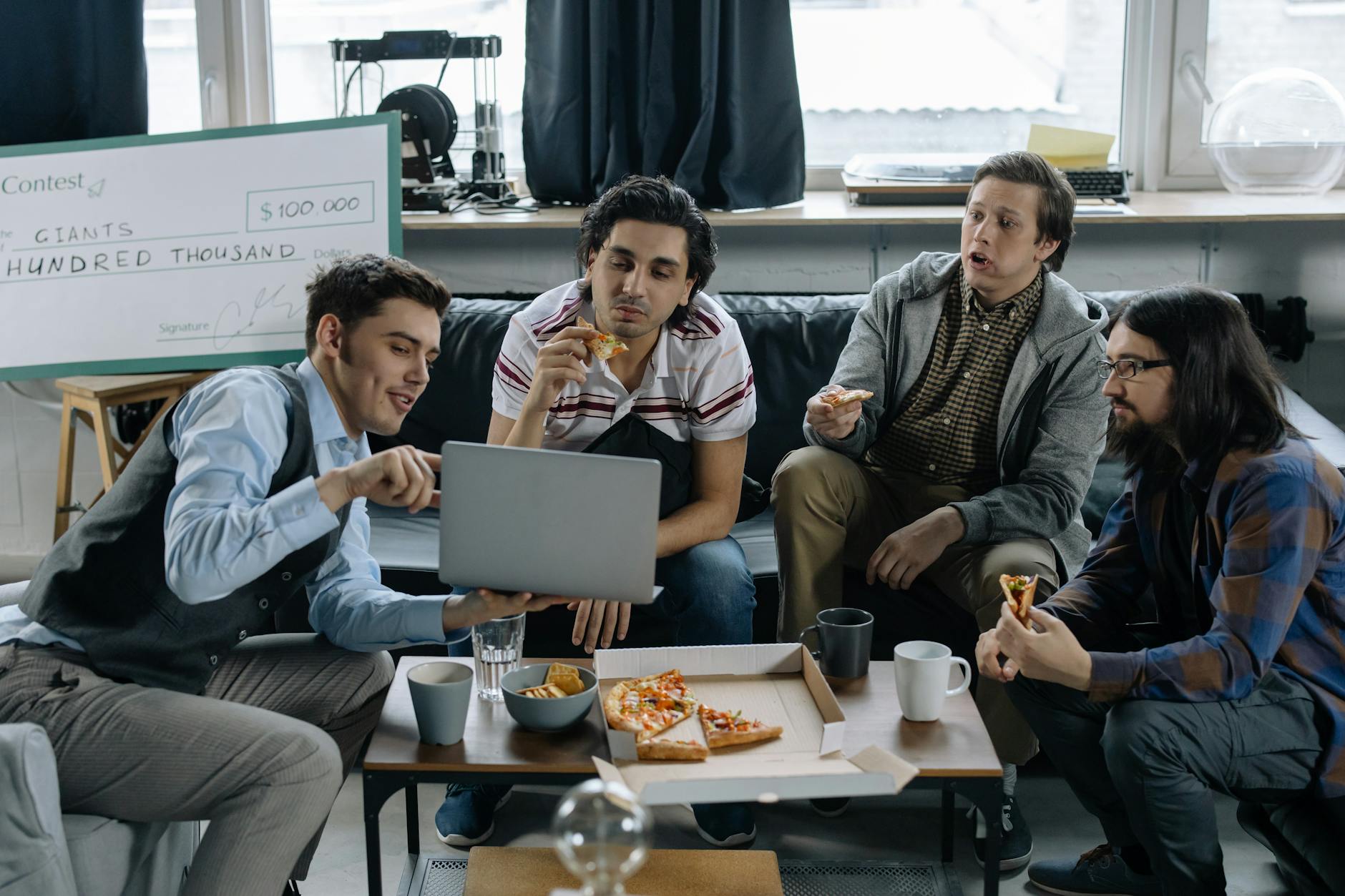 start up team discussing a project over a pizza